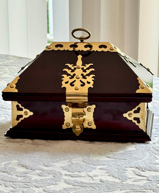 Rosewood  Netturpeti jewelry box with gold accents on a textured surface