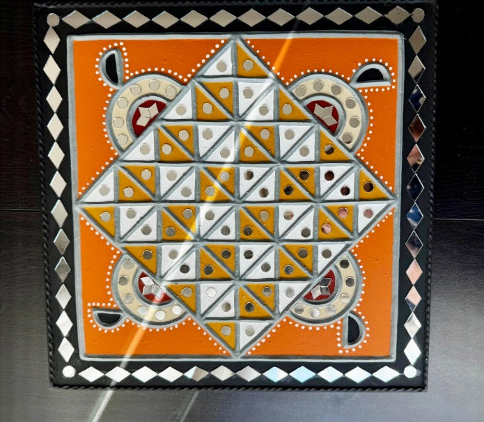 Decorative Lippankaam art  tile with geometric pattern on an orange background