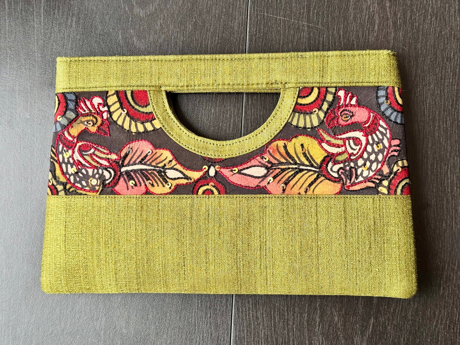 A collection of hand-painted kalamkari clutch purses in various colors, featuring intricate patterns.
