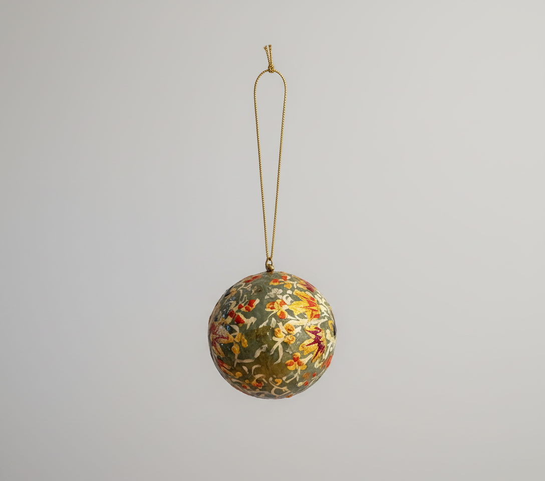 Decorative floral ornament hanging on a Christmas tree branch.