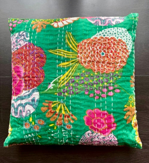 Decorative pillow with colorful floral pattern on a green background