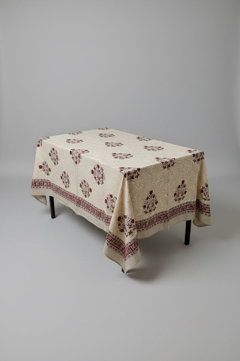 Living room with a table covered by a decorative hand block print tablecloth, lamp, and couch.