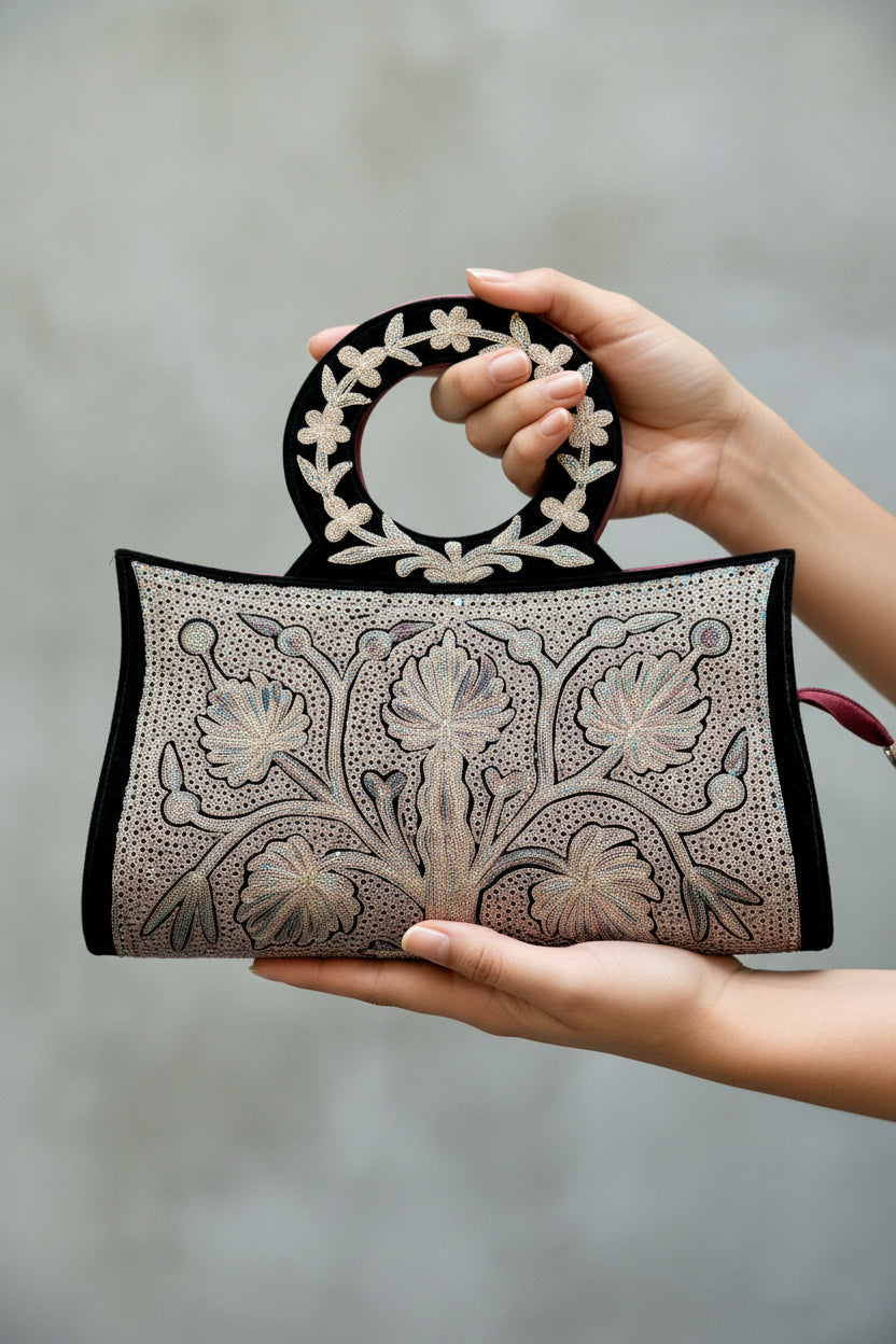 Decorative Kashmiri embroidery handbag with floral patterns on a wooden surface