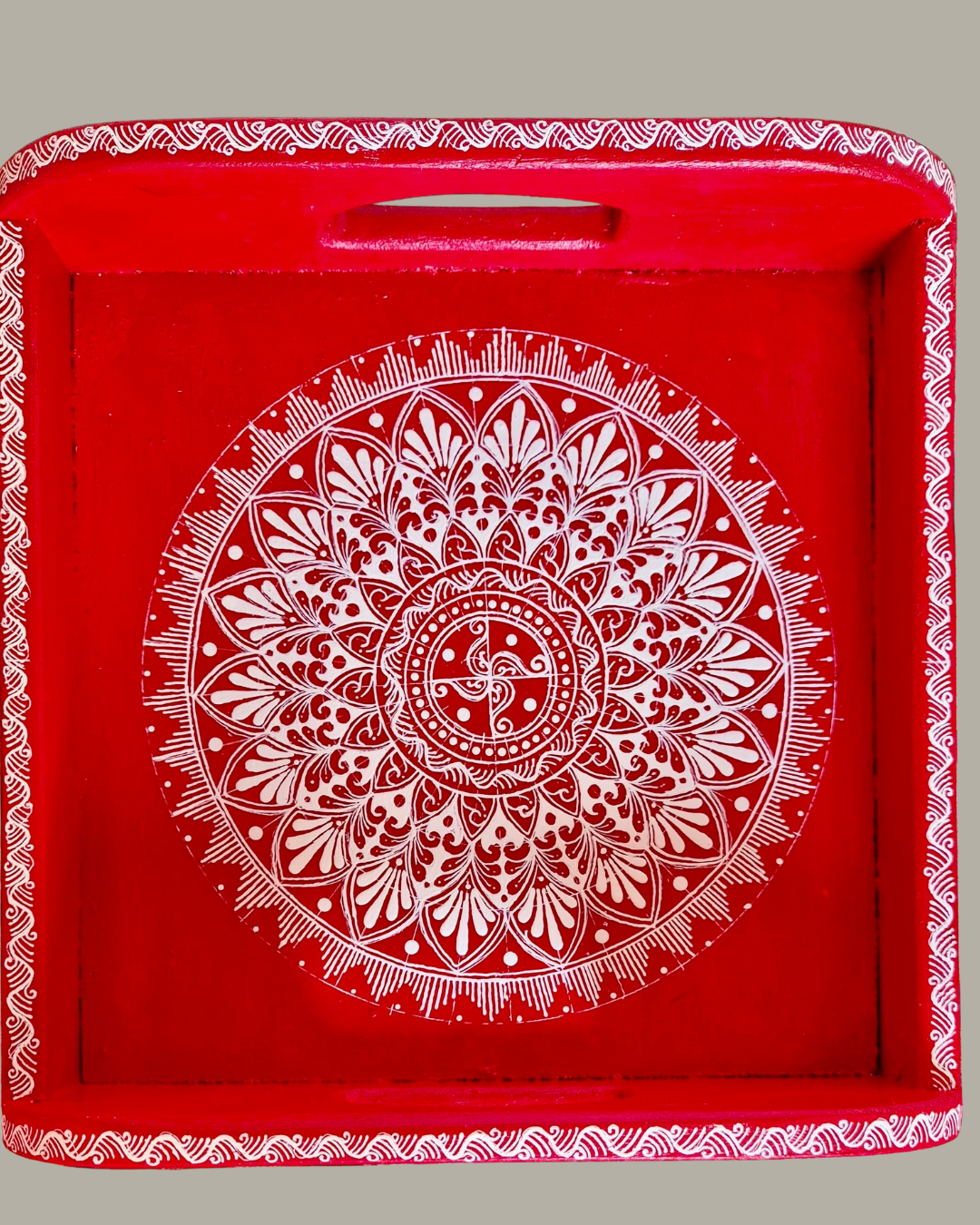 Red tray with white mandala design in Aipan art style on a gray background