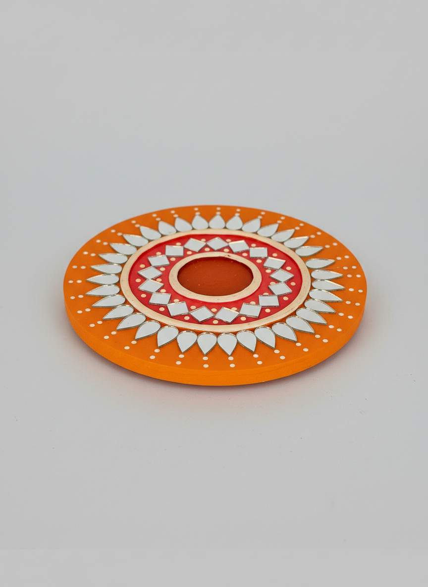 Decorative circular object with orange, red, and white pattern on a light gray background