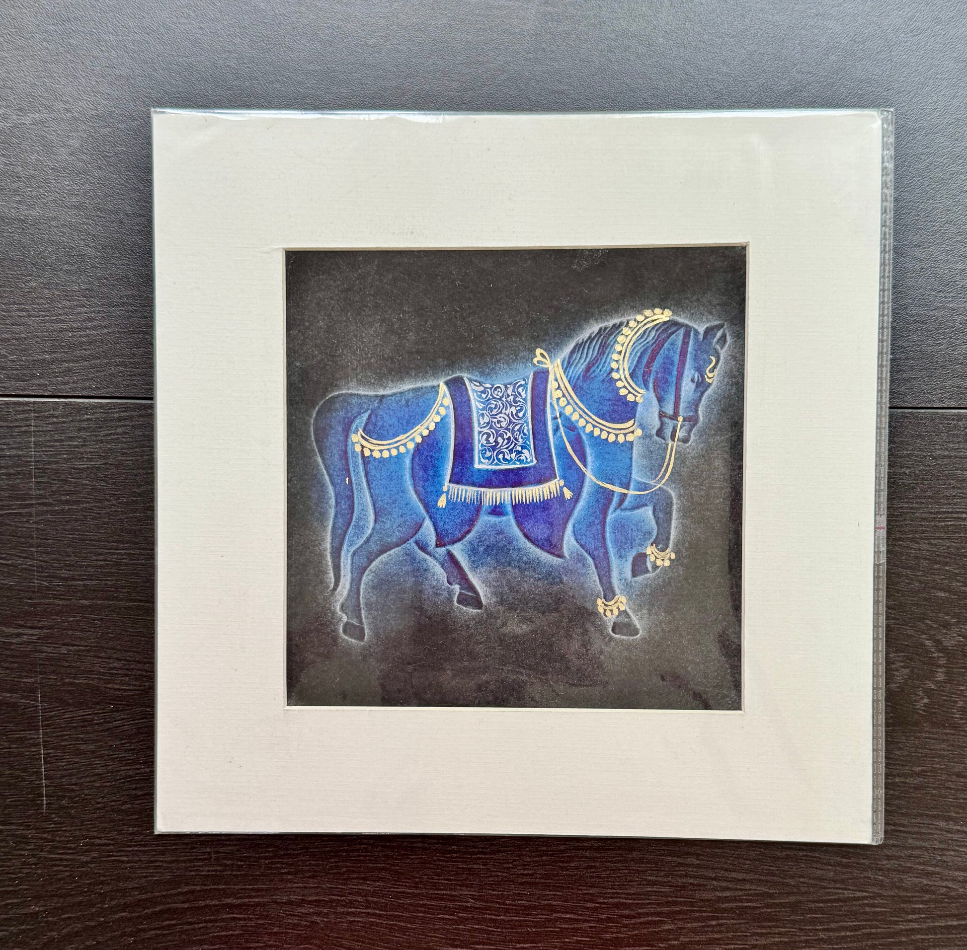Framed nail drawn artwork of a blue horse with gold details on a dark background