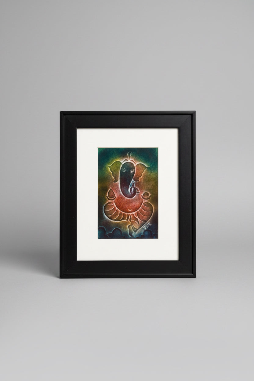 Framed artwork of Ganesha face with a black border on a textured surface.