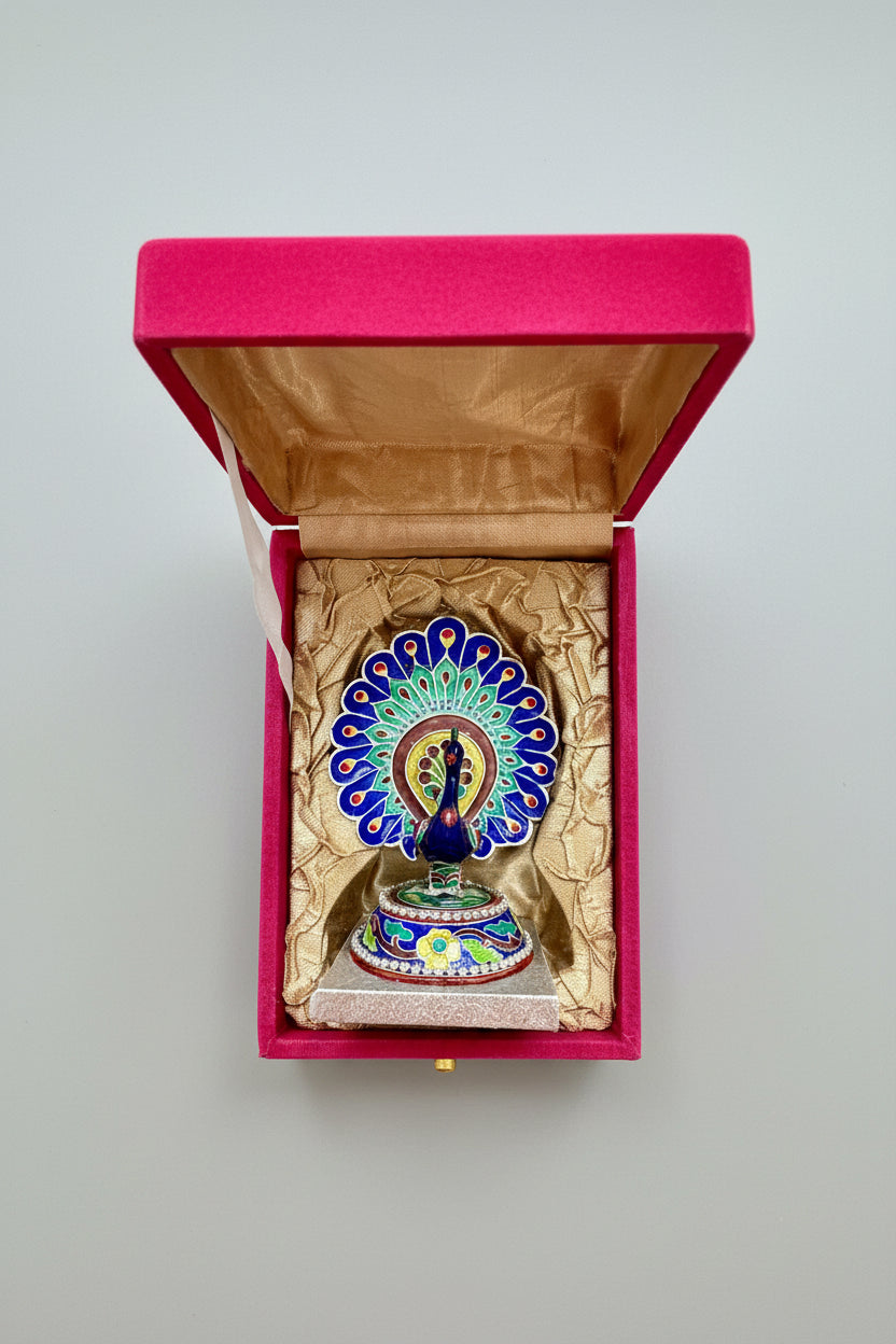 Colorful Gulabi Meenakari silver  peacock feather decoration in an open pink box on a gray background