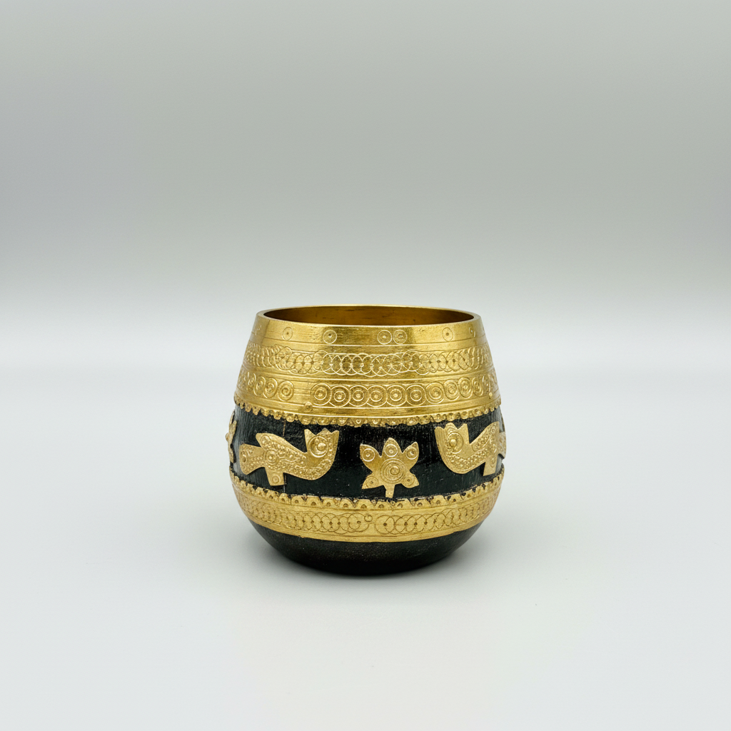 Decorative black and gold Sherpai bowl with intricate patterns on a wooden surface