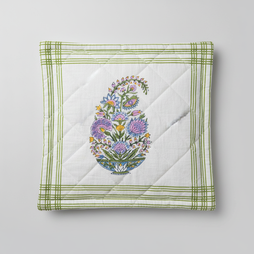 Quilted square cushion cover with floral hand block printed design and green border on a light gray background