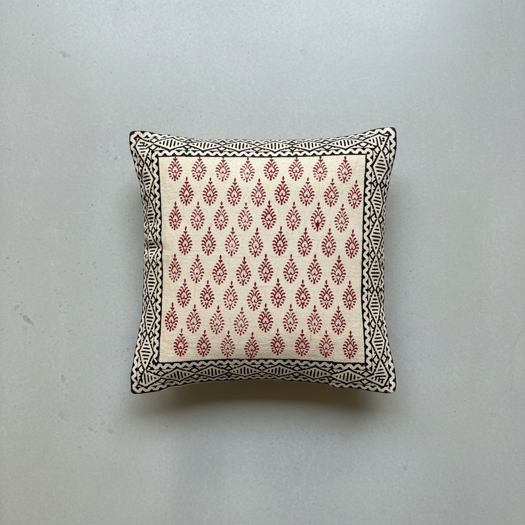 Decorative pillow with red Bagru hand block print pattern on a light gray background
