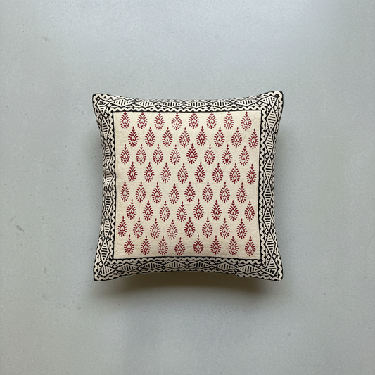 Decorative pillow with red Bagru hand block print pattern on a light gray background
