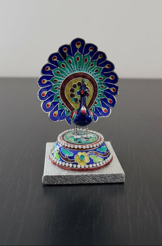 Decorative Gulabi Meenakari peacock figurine on a silver stand with a colorful design against a plain background