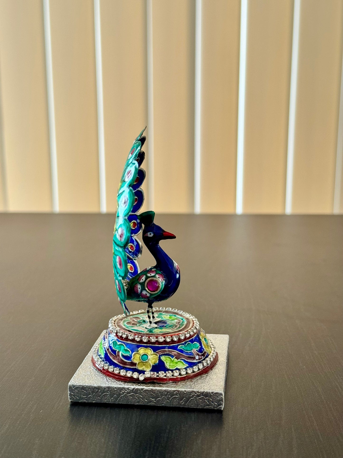 Other side of Gulabi Meenakari silver  peacock figurine on a stand with a neutral background