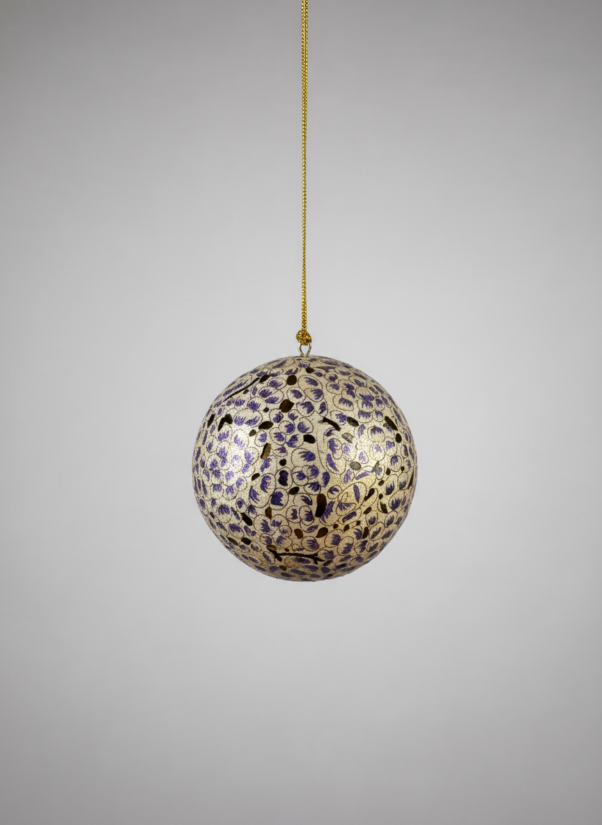 Decorative ball with purple and gold pattern hanging on a gray background