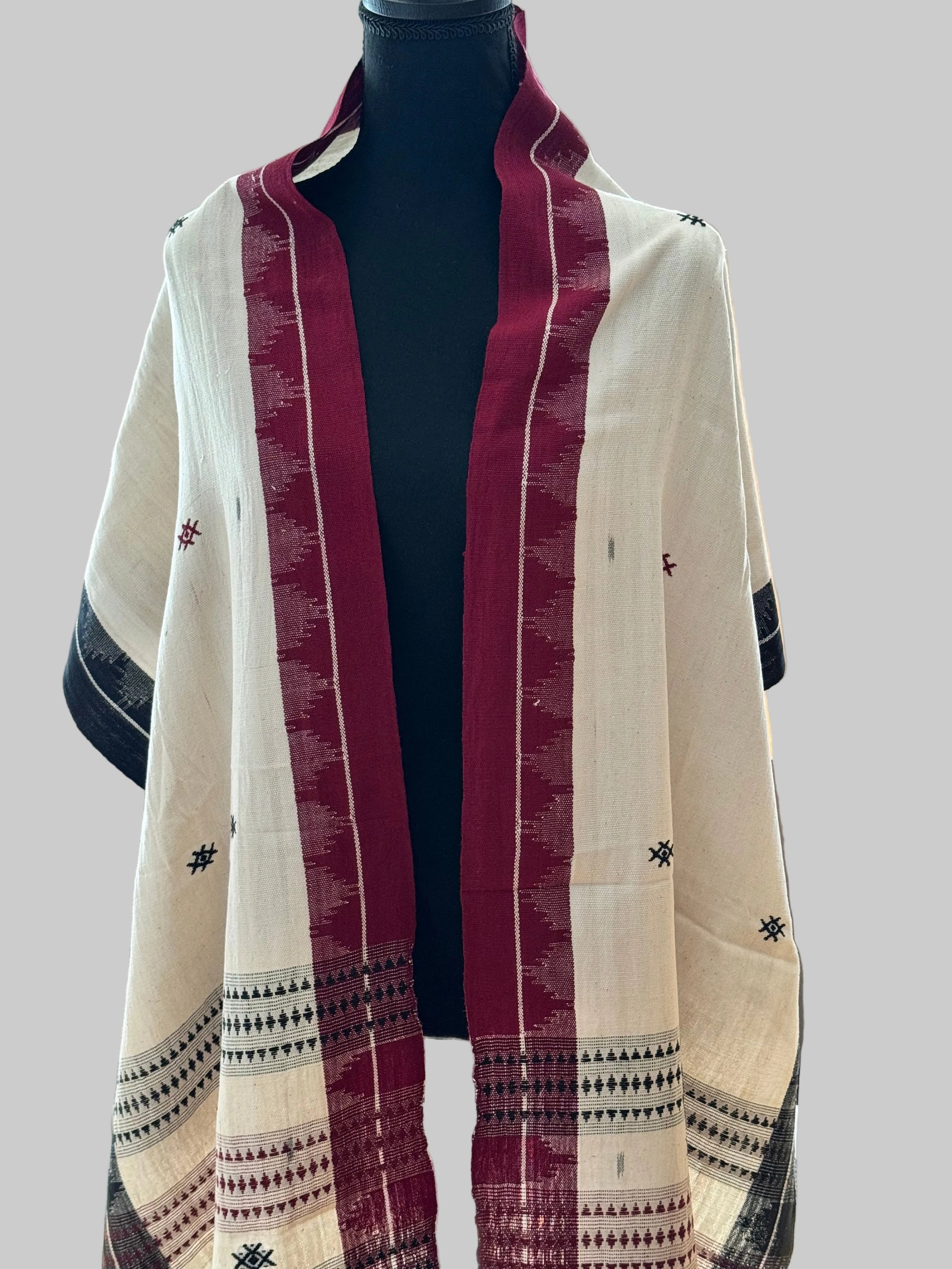 Traditional Kotpad weave cotton stole  with red, white, and black patterns draped over a surface.