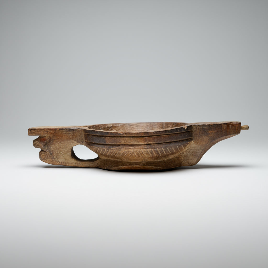 Wooden bowl with decorative carvings on a textured surface