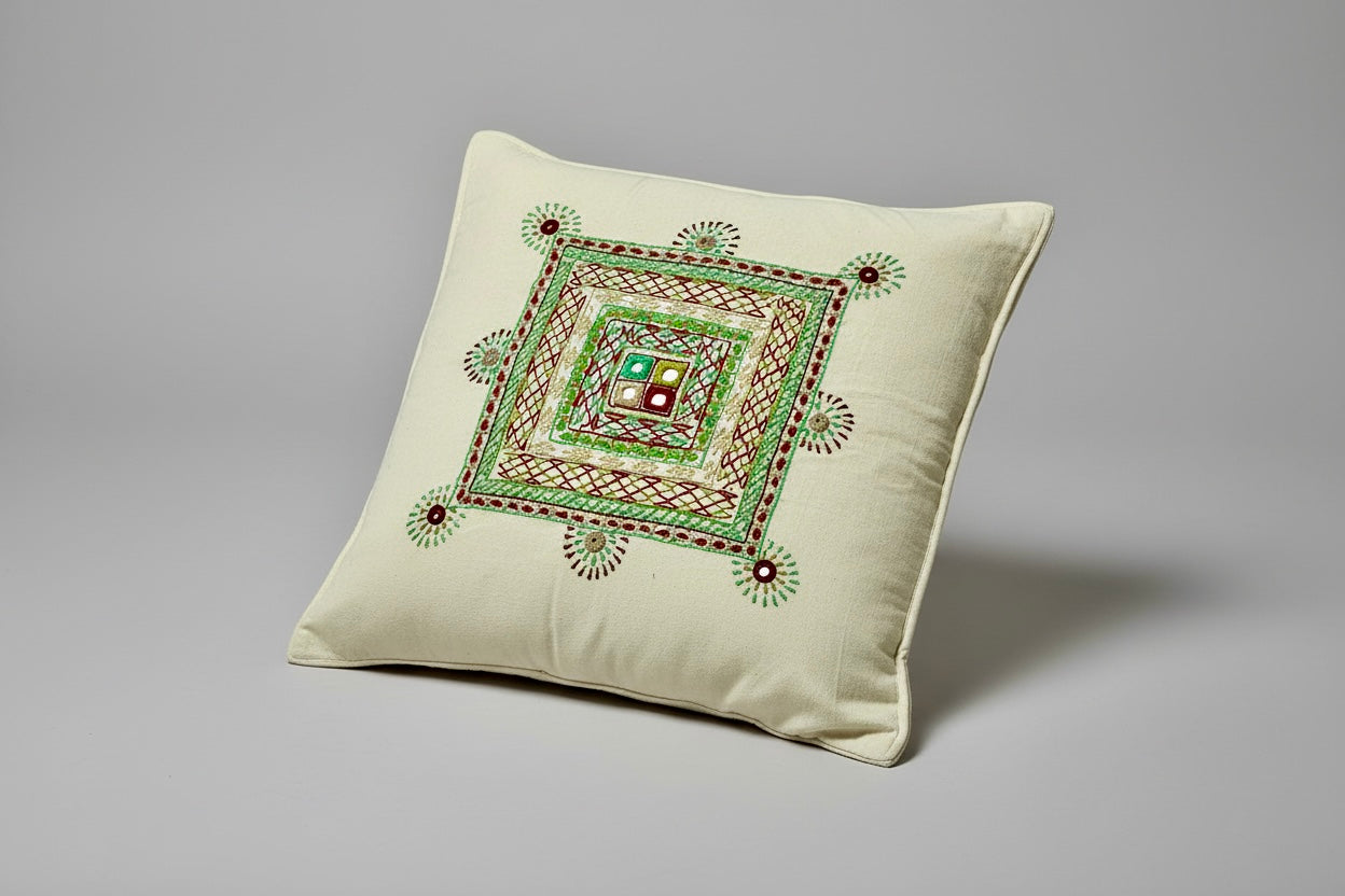 Decorative pillow with intricate green Lambani embroidery on a gray background