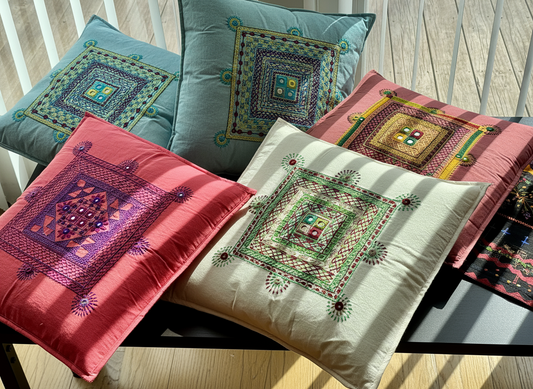 Set of embroidered cushions on a wooden surface