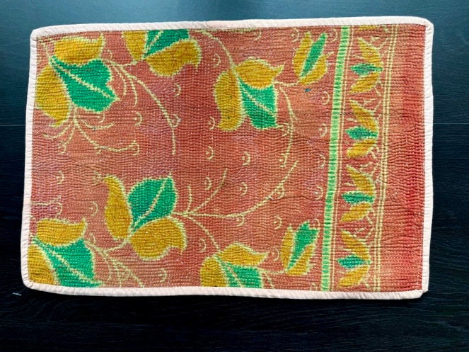 Orange placemats with leaf pattern on a dark background