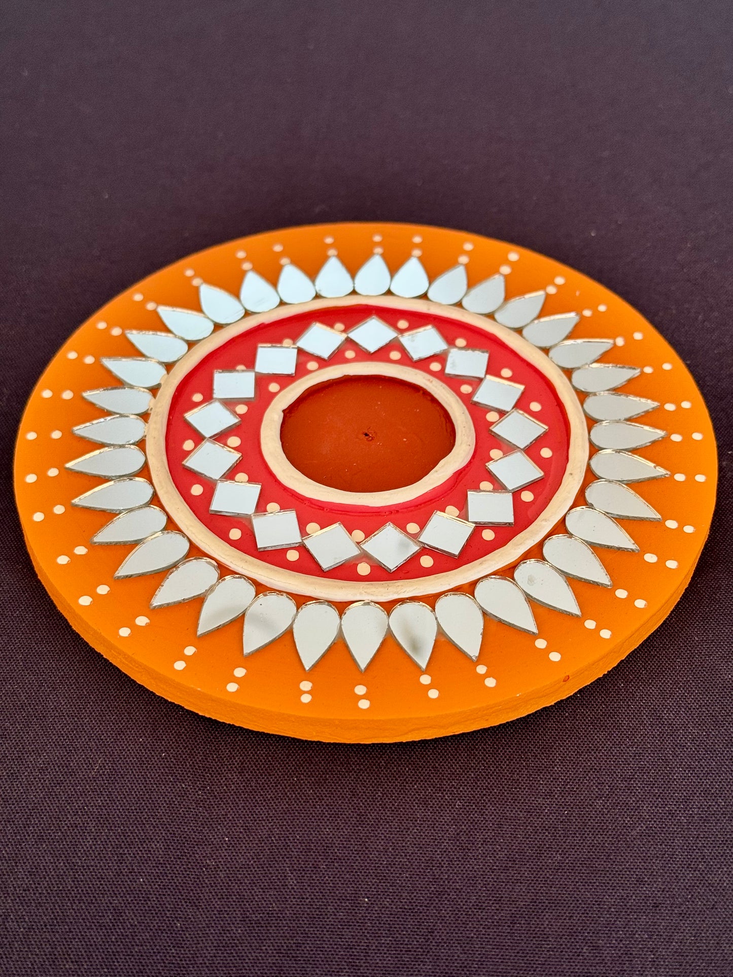 Decorative plate with a central design on an orange background