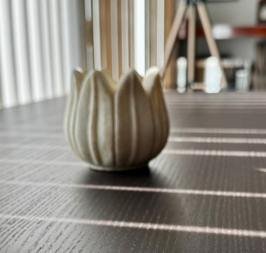 Decorative marble tea light holder on a textured surface with blurred background