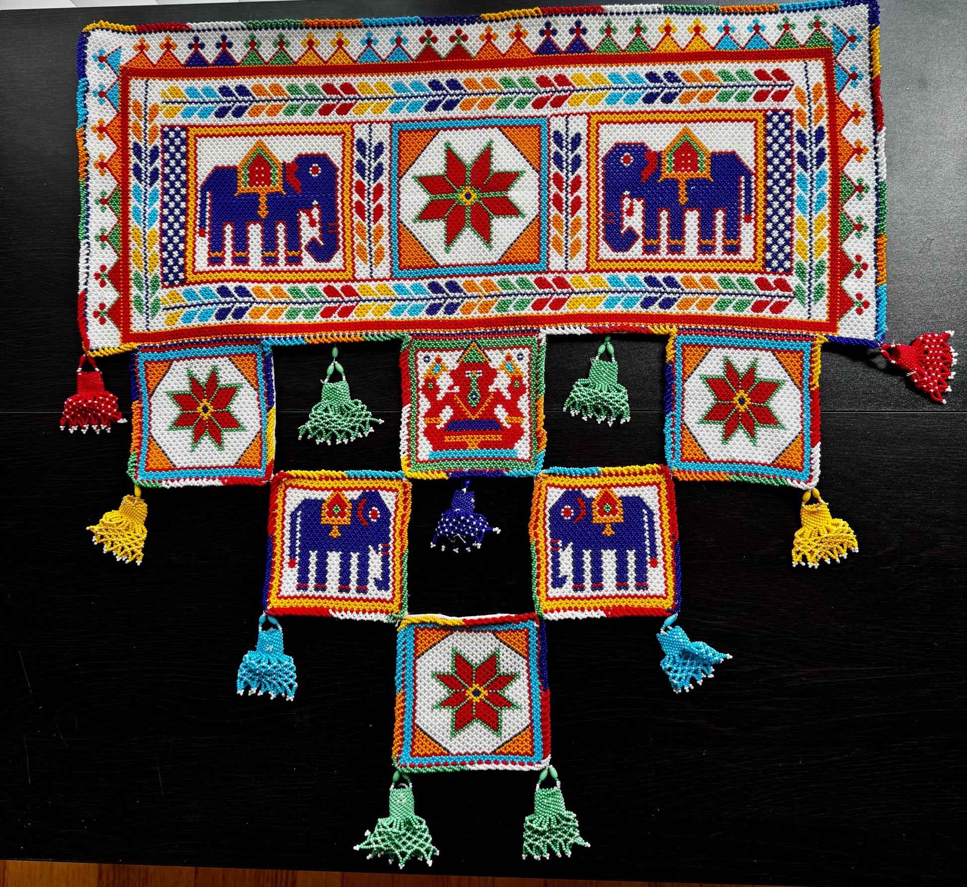 Colorful Motikaam with patterns and tassels on a black background