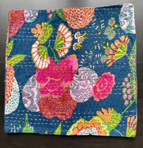 Colorful floral and butterfly patterned fabric on a dark surface