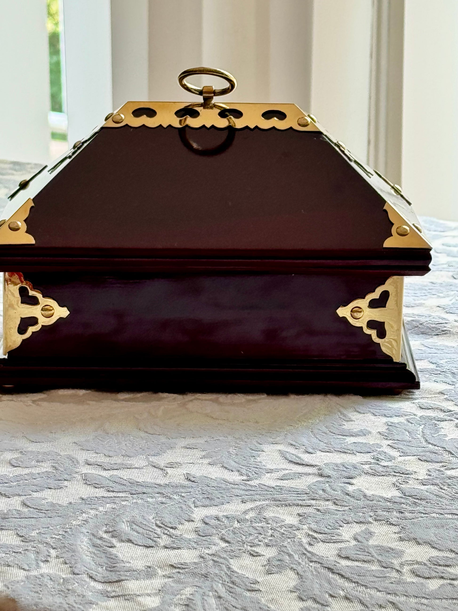 Back of Netturpeti, a Decorative wooden box with gold accents on a textured surface
