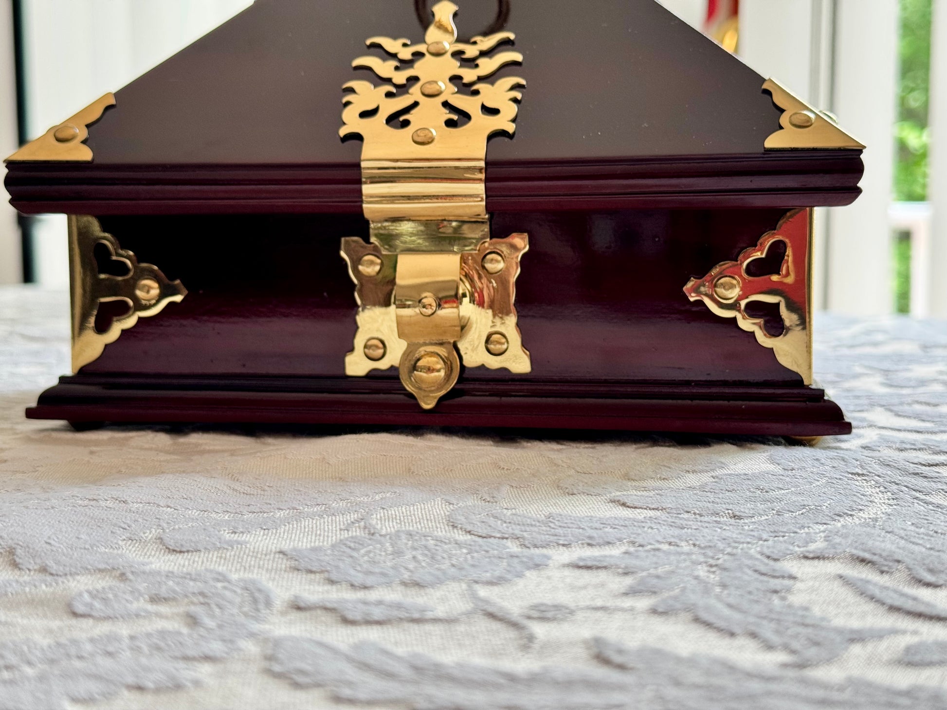 Rosewood Netturpeti, jewelry box with brass hinges on a textured surface
