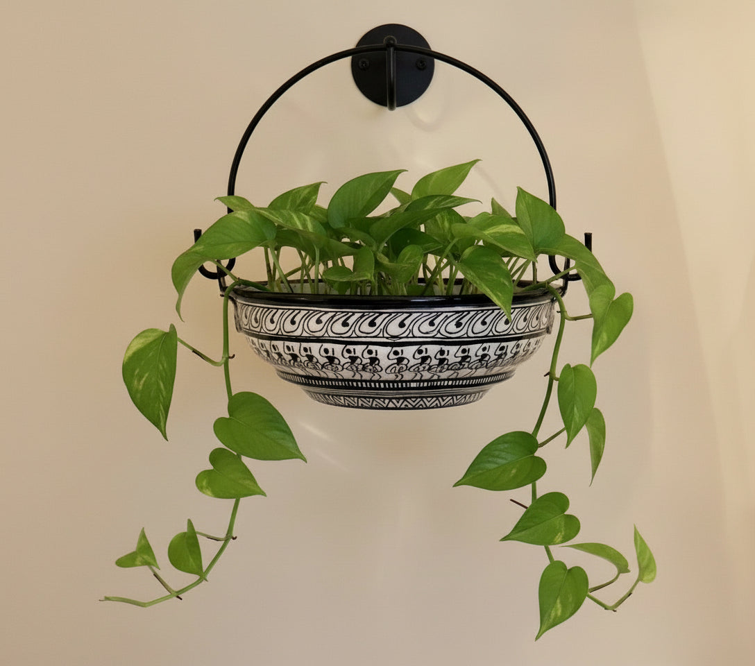 Decorative metal basket with black handle on a beige background