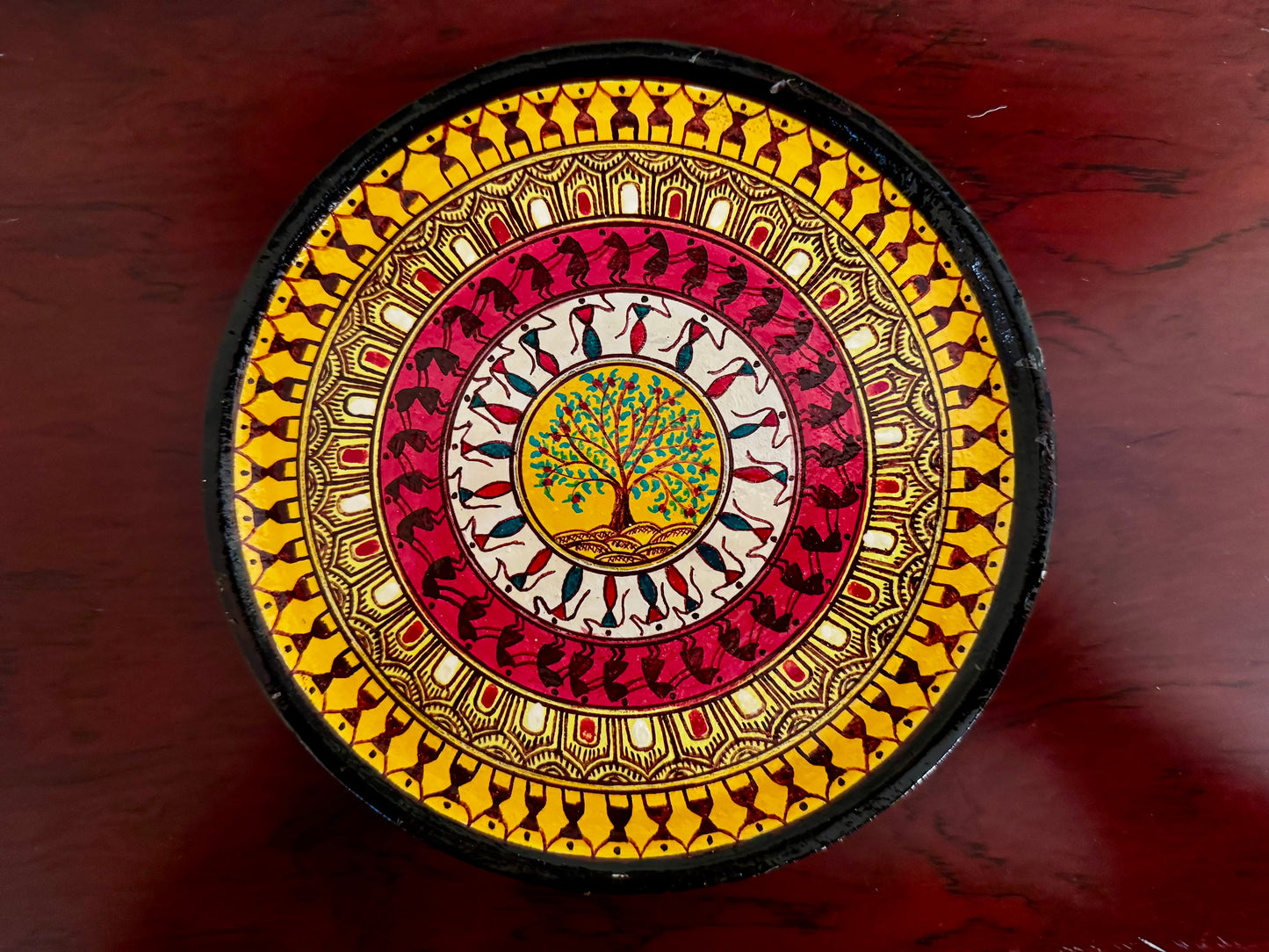 Decorative circular object with intricate patterns on a wooden surface