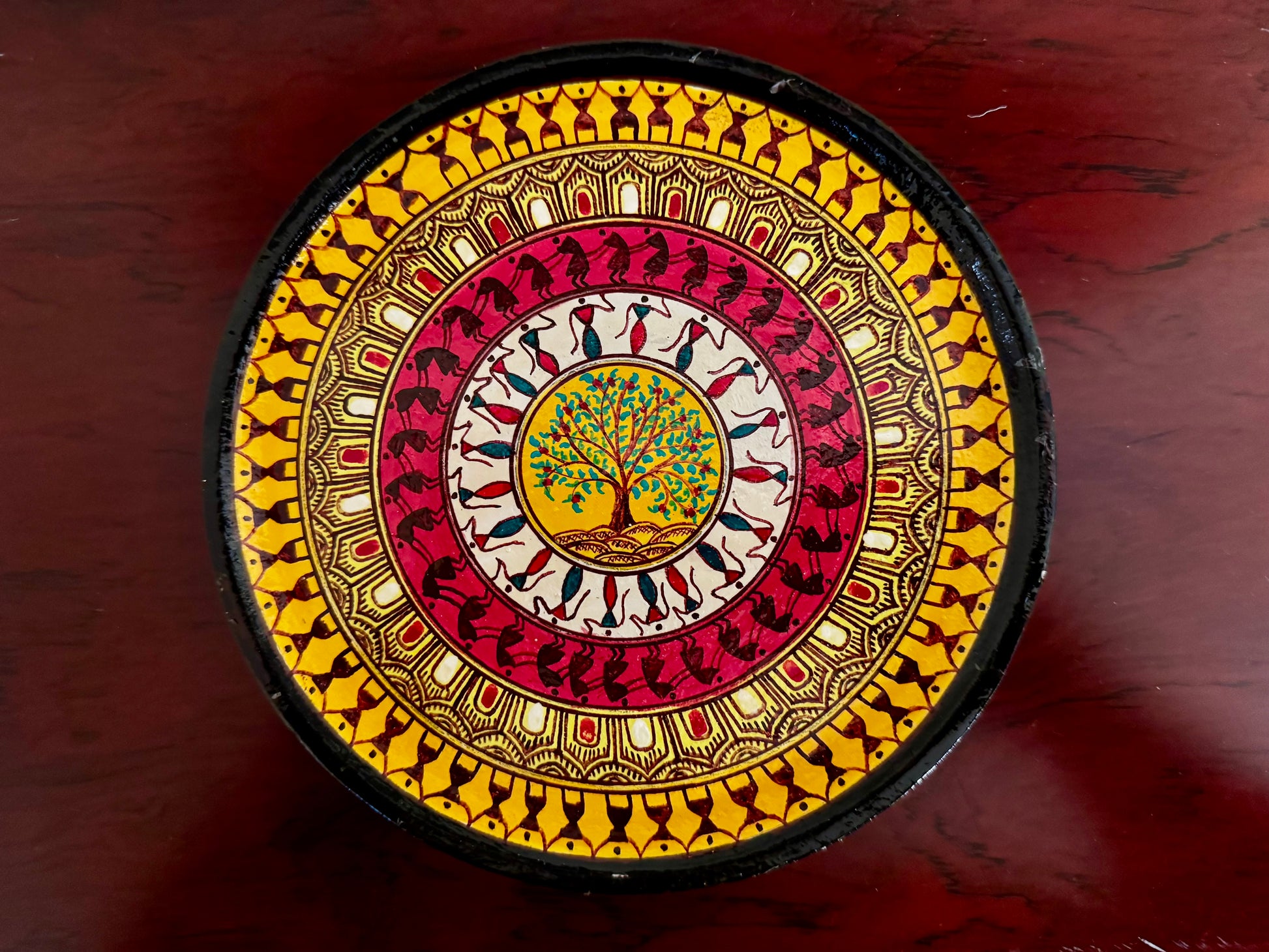 Decorative circular object with intricate patterns on a wooden surface