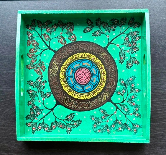 Decorative tray with floral patterns and a central circular design on a green background