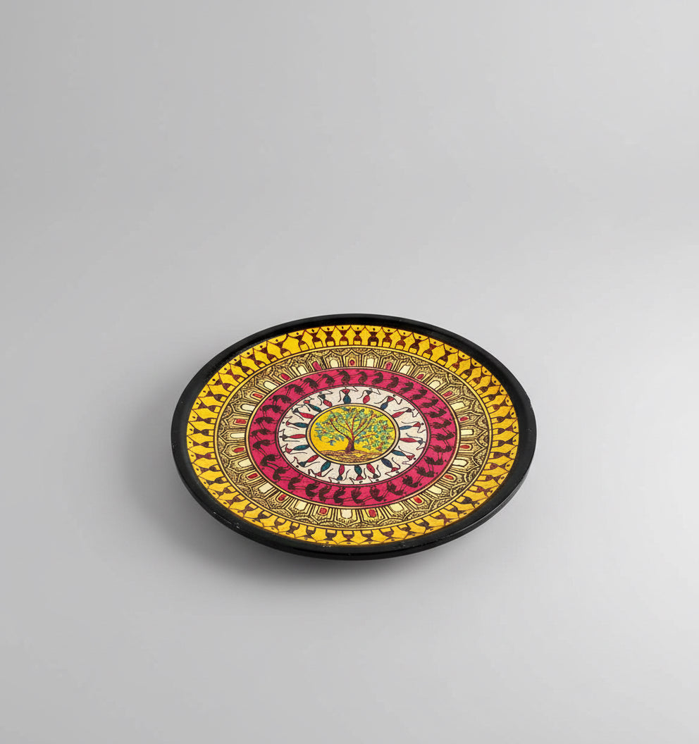 Decorative circular plate with intricate designs on a wooden surface
