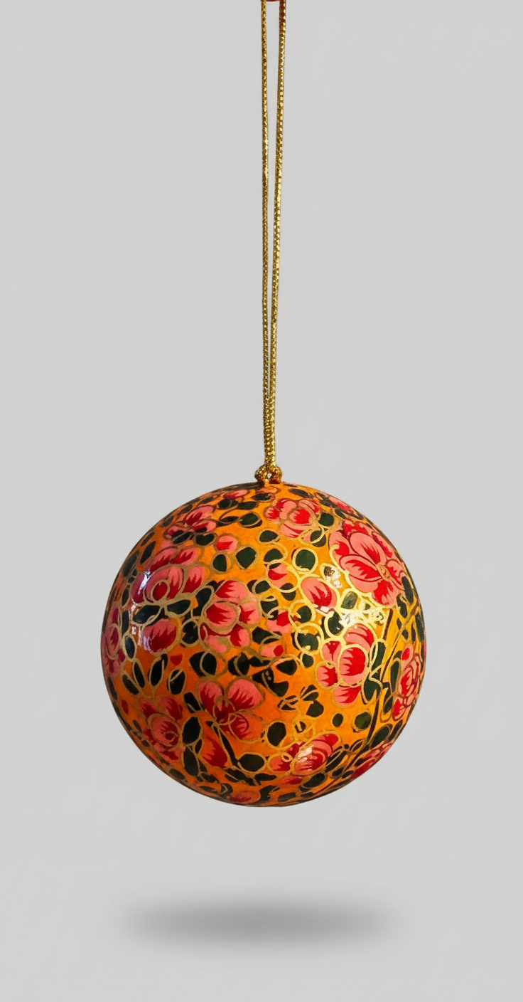 Decorative ball with floral pattern hanging on a string against a gray background