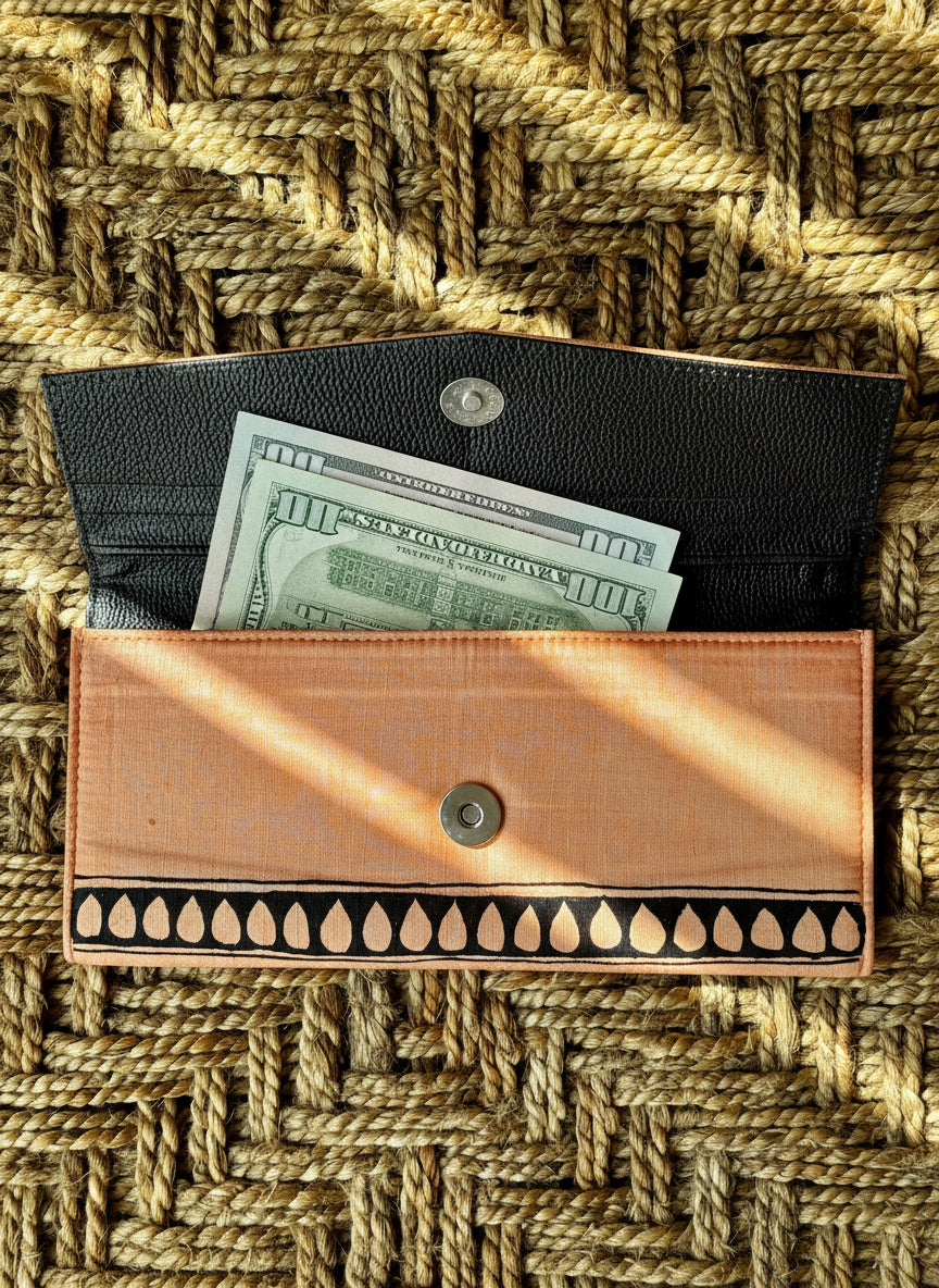 Black hand painted Madhubani peach wallet  with decorative pattern on a woven mat background