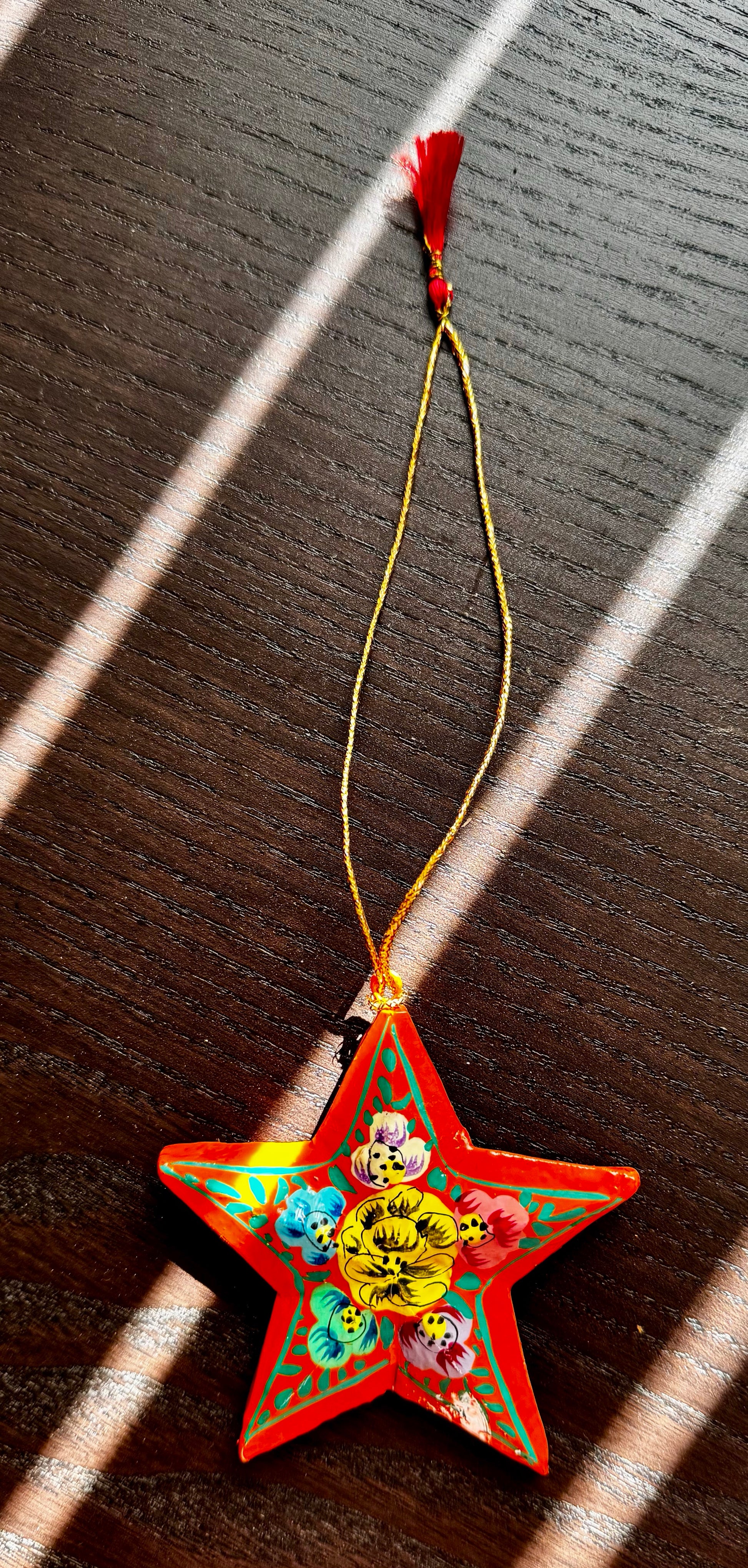 Decorative star-shaped object with colorful designs on a wooden surface