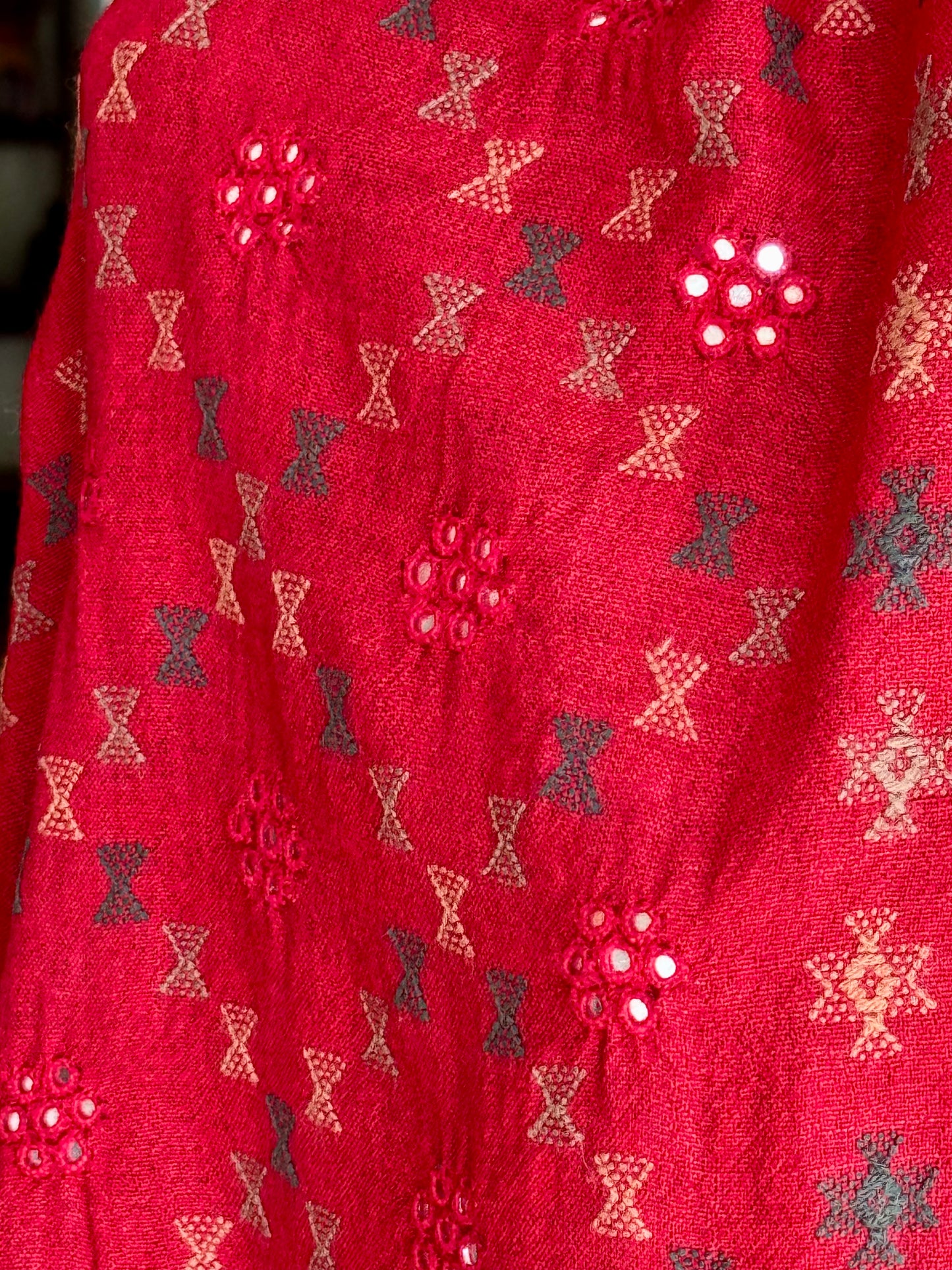 Close-up of a red stole with decorative pattern hand embroidered in Kutchi Soof style..