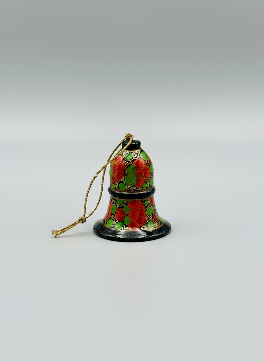 Decorative bell with floral patterns on a wooden surface