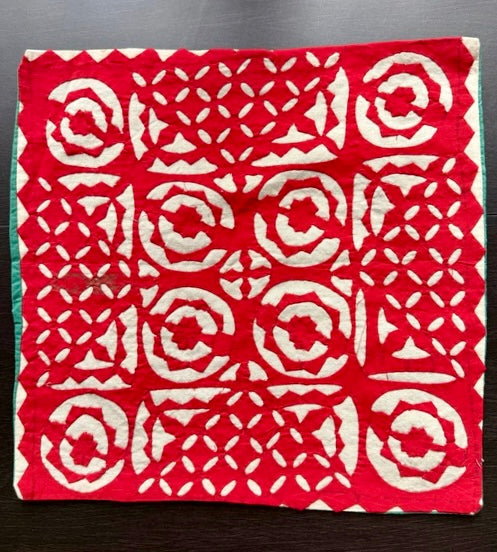 Red fabric with white geometric pattern on a dark surface