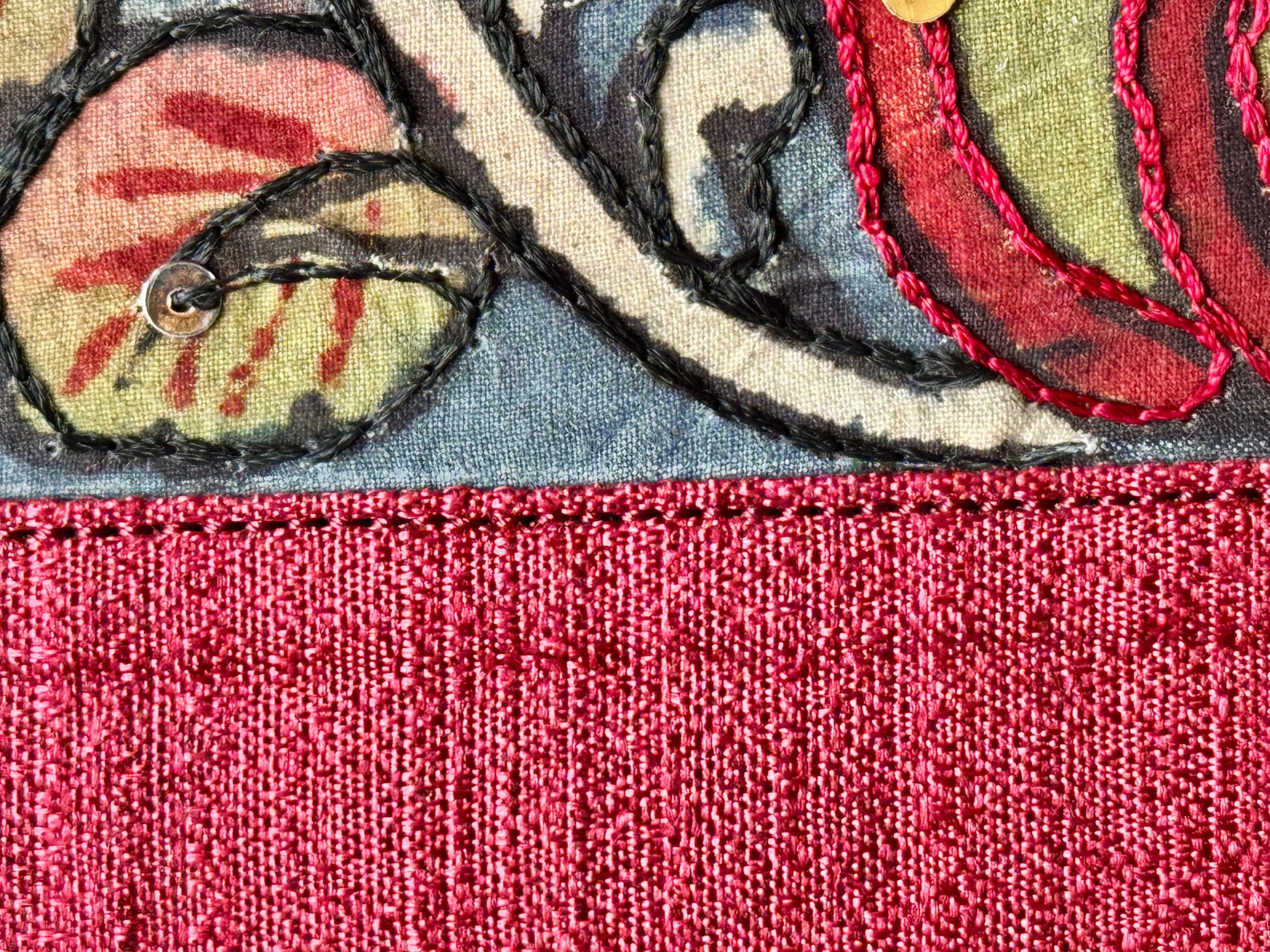 Closeup of maroon raw silk hand painted Kalamkari clutch bag