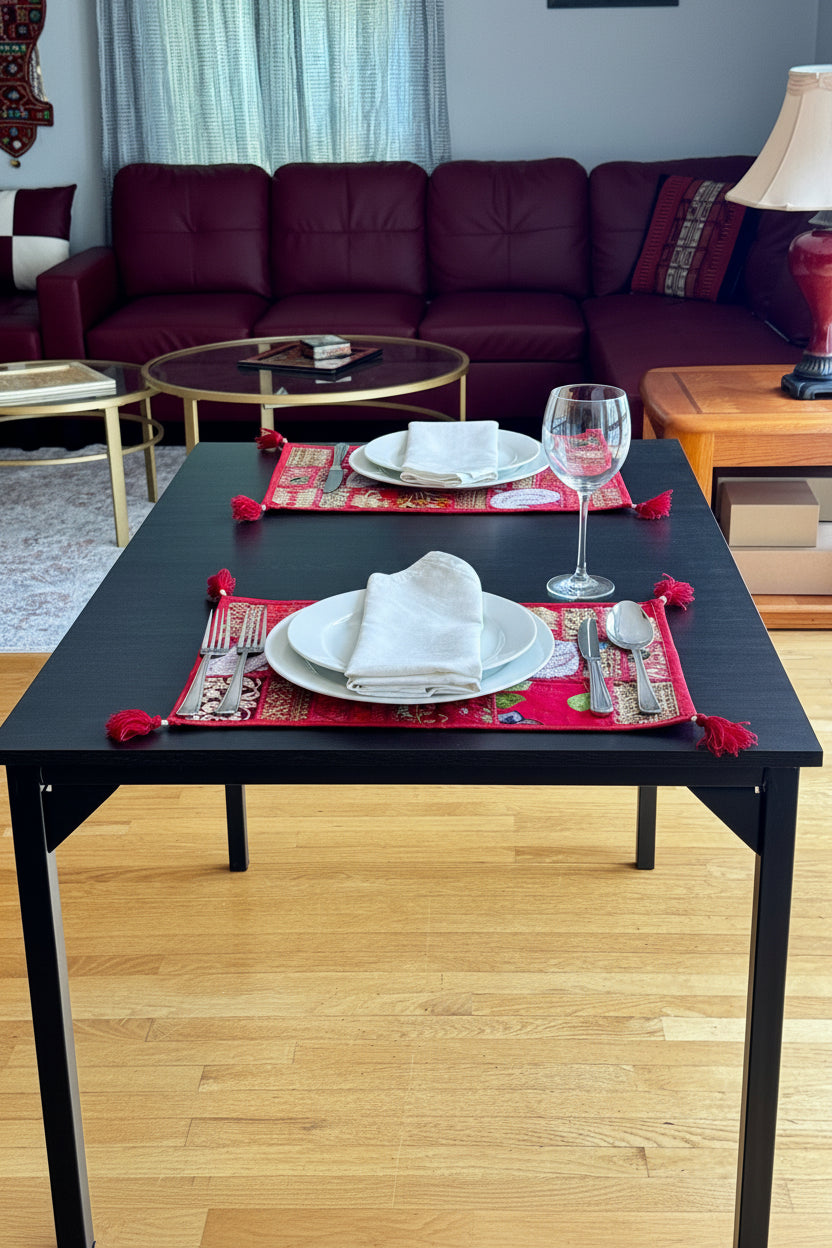 Living room with a dark coffee table featuring red Khambhadia patchwork decorative placemats, surrounded by furniture.