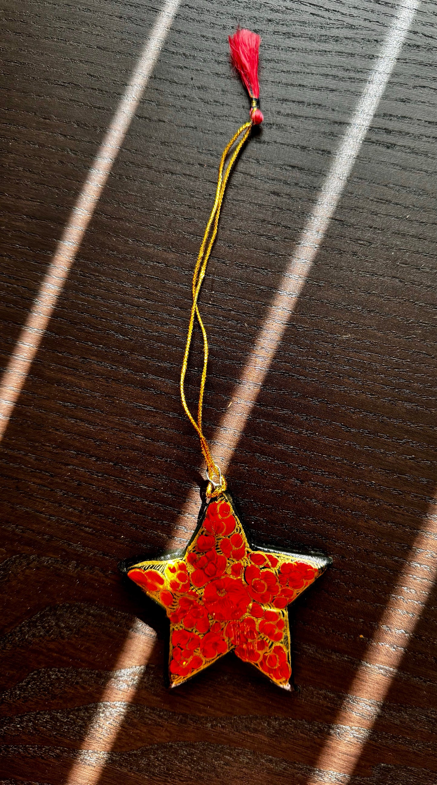 Red star-shaped ornament with gold accents on a dark surface