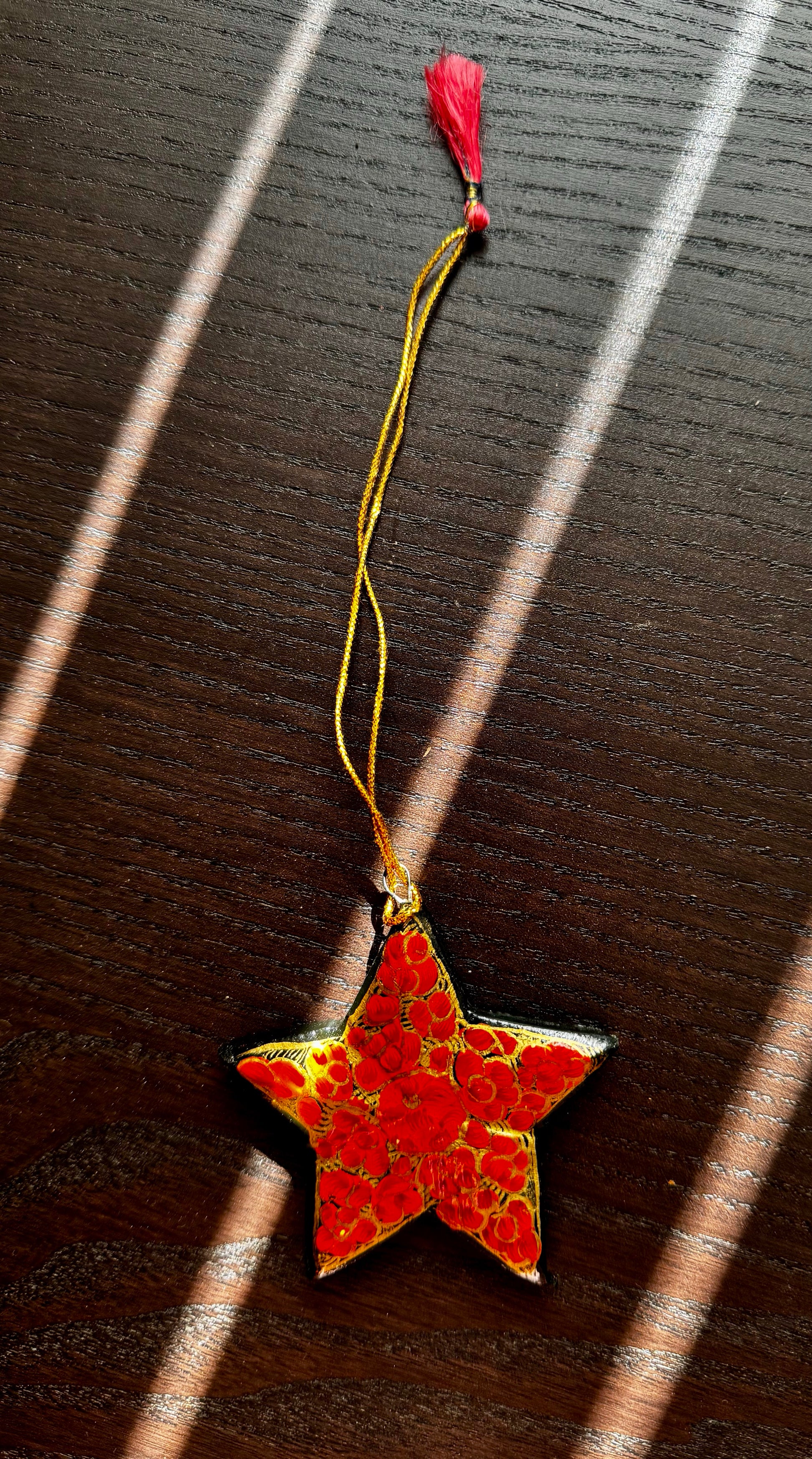 Red star-shaped ornament with gold accents on a dark surface