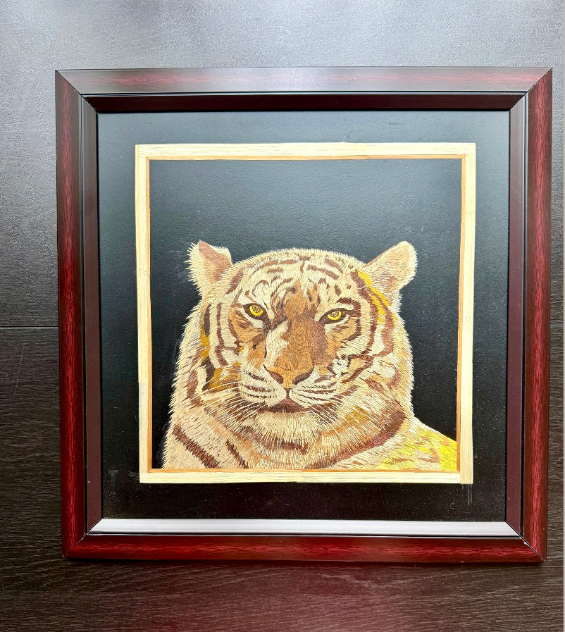 Framed Rice straw artwork from Kerala of a tiger's face on a dark background