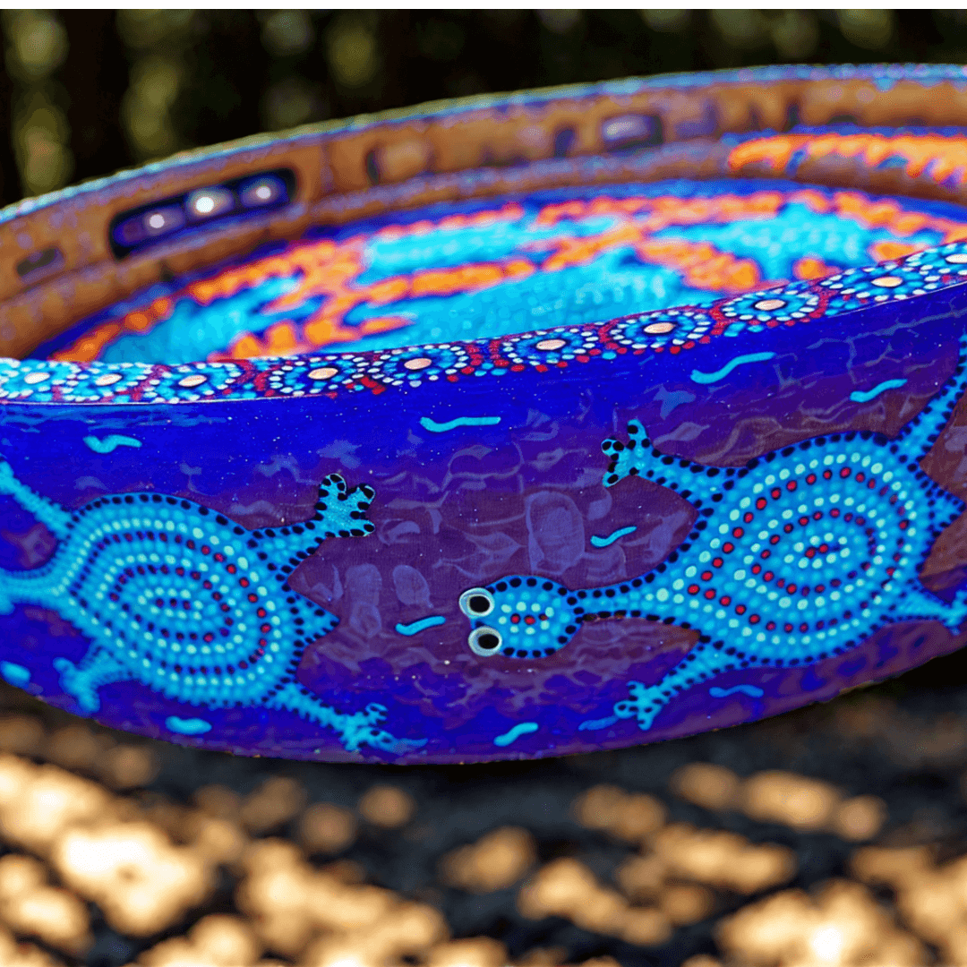 Decorative side of tray with blue and purple Bhil  art patterns on a blurred background