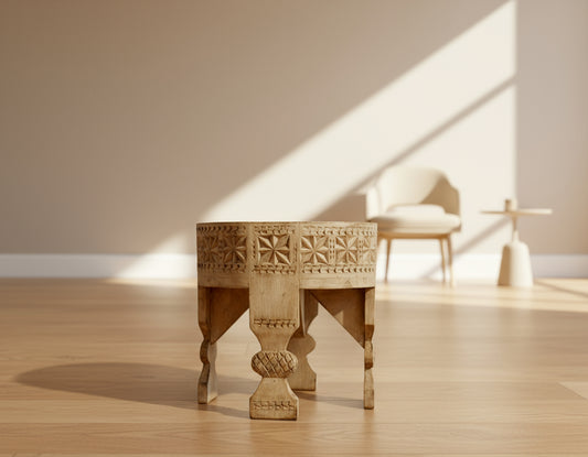 Decorative wooden stool on a wooden floor with a blurred background