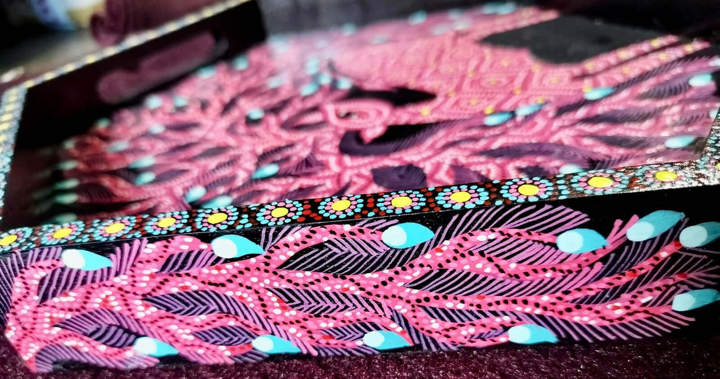 Decorative  Tray side with Bhil art with pink and black pattern on a dark background