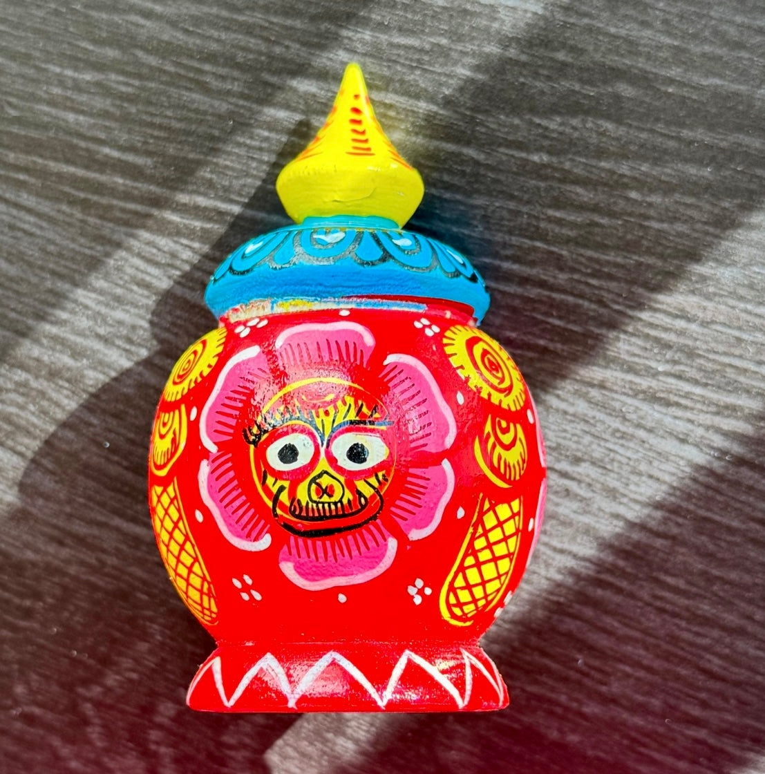 Colorful decorative item with a face design on a wooden surface